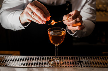 Barman in a white shirt making a cocktail with a smoky note