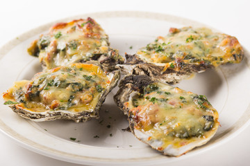 Four Oysters Rockefeller on a white plate