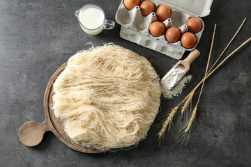 Shredded thin dough with ingredients on table
