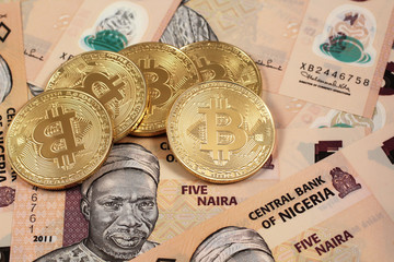 A close up image of golden bitcoins close up with Nigerian naira notes