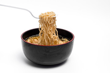 Instant noodles and cup isolated on white background.Instant noodles for people Do not like to eat vegetables.Instant noodles in black cup on white background.