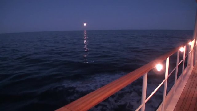 Yacht sails on background of night moon in ocean. Dream of beautiful lifestyle. Evening in luxury style.