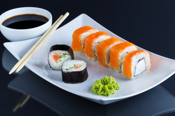 Philadelphia roll sushi with wasabi and soy on white plate. Sushi menu. Japanese food. 