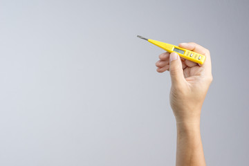 Hand holding screwdriver digital lcd circuit or voltage tester