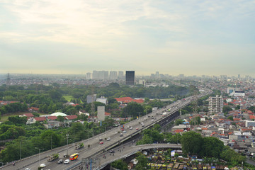 Cityscape of Jakarta city with buildings, houses, and busy road.