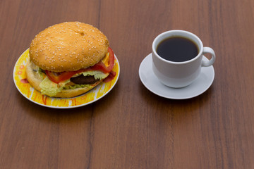 Delicious hamburger and cup of coffee on wooden table