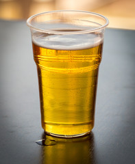 Fresh beer in a plastic glass on the table