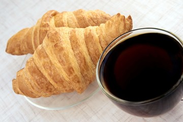 Delicious dessert. Fresh croissant. Cup black tea