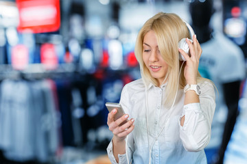 Happy young blonde woman listening to music