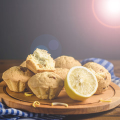 Lemon cupcakes on a wooden Board on the table with a blue towel. Free space for text.