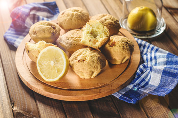 Lemon cupcakes on a wooden Board on the table with a blue towel.