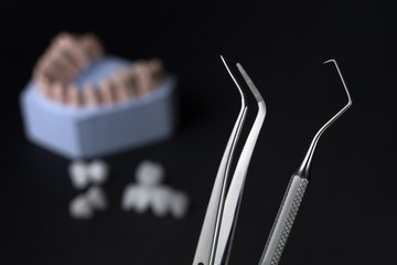 Dental tools with zircon dentures on a black background - Ceramic veneers - lumineers