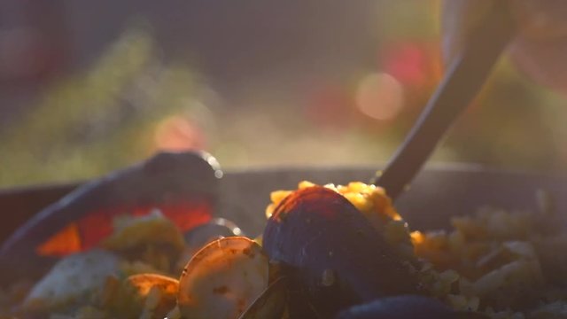 Seafood Paella. Traditional spanish paella with prawns, mussels and fish closeup. Slow motion 4K UHD video footage. 3840X2160