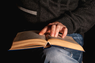 the book holds on his knees a hand from above