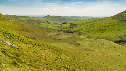 Obraz premium Welsh landscape with some wind turbines and the sea in the background, near Tal-y-bont, Ceredigion, Dyfed, Wales, UK