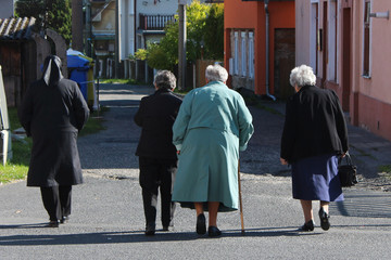 Four old ladies friends walking down the street