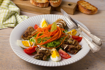 Chicken liver, carrot, eggs, tomatoes, lettuce and fried onion salad. Liver and vegetables