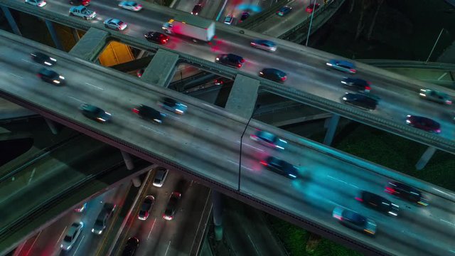 Cinematic urban aerial time lapse view of downtown Los Angeles freeways, highways and roads with traffic and night.