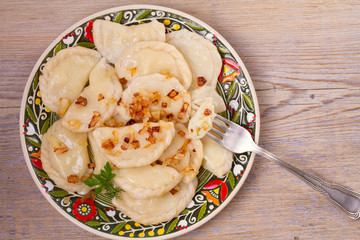 Dumplings, filled with potato and served with fried onion. Varenyky, vareniki, pierogi, pyrohy. overhead