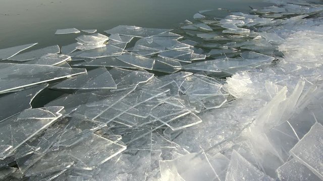 Ice pushed by the wind on Utah lake towards the shore and piling up as moves along the edge.