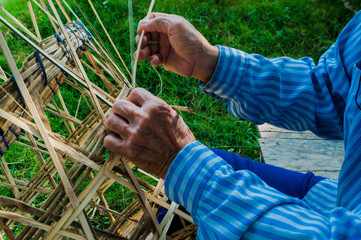 The basket-maker,Weave pattern hand bamboo, Bamboo weaving,Basket weaving , a village industry in thailand,Old Man's hands making a wicker basket