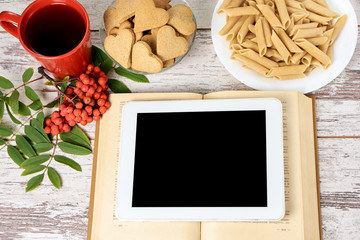 Work on tablet. Old book. Ginger cookies hearts