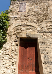 Old wooden door on stone  house  in Gordes. Provence, France