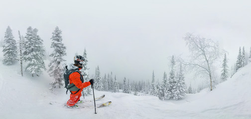 Man skier freerider standing at top of ridge, adventure winter freeride extreme sport