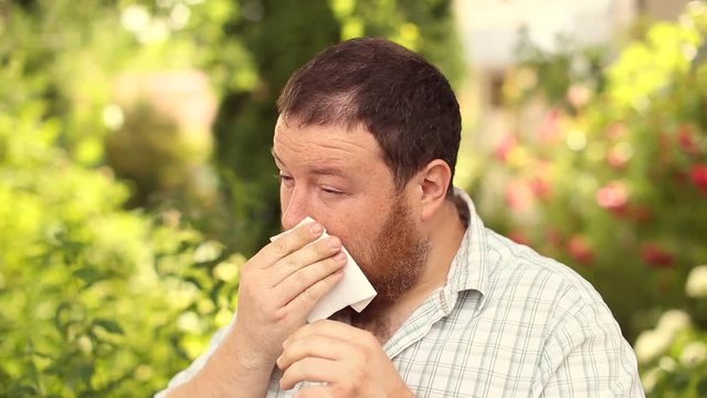 A bearded man suffers from pollen