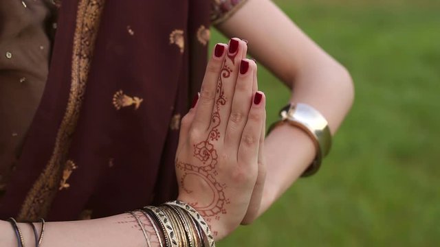 Close-up of the crossed arms of an Indian girl with pictures of mehendi.