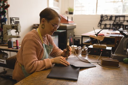 Worker stitching leather with stitching machine