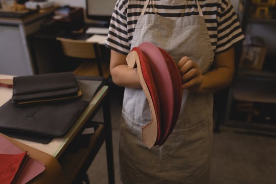 Worker holding leather in workshop