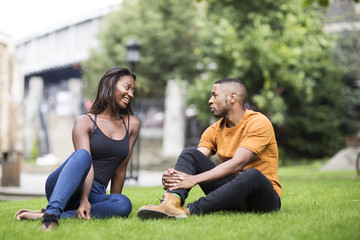 Naklejka premium young couple sitting in the park together