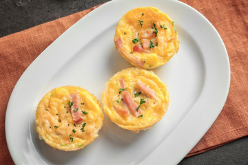 Plate with tasty egg muffins on table