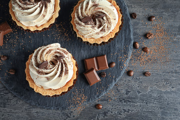 Slate plate with tasty cakes on table, top view