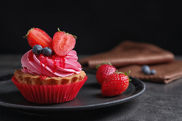 Plate with tasty cake on table