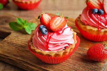 Wooden board with tasty cakes, closeup