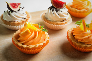 Wooden board with tasty cakes, closeup