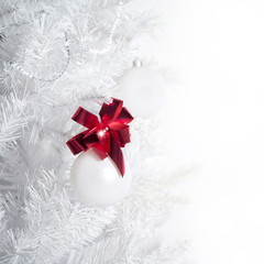 Fototapeta na wymiar Decorated artificial white Christmas tree with white minimalistic balls and red ribbon
