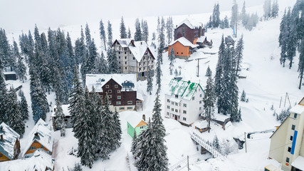 Snow-covered ski resort in the mountains with Christmas trees