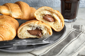 Plate with yummy fresh chocolate croissants on table