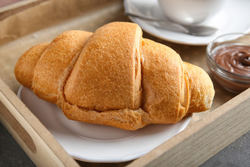 Tray with yummy croissant on table, closeup