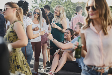 Couple sitting and drinking alcohol at outdoor party - obrazy, fototapety, plakaty