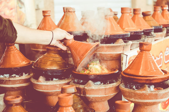Cooking traditional Moroccan dish, meat and vegetable in ceramic tajine in Marrakech in Morocco.