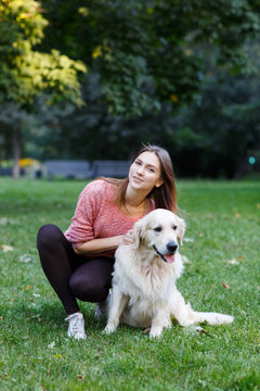 Image of girl hugging dog on green lawn
