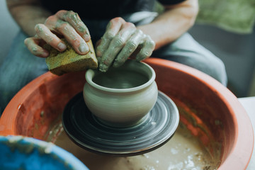 Potter hands makes clay pot on the pottery wheel