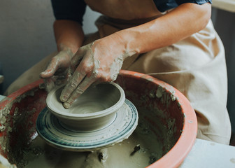 Potter hands makes clay pot on the pottery wheel