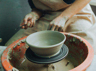 Fototapeta na wymiar Woman hands makes clay pot on the pottery wheel