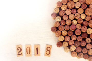 gourmet collection 2018/ wooden plaques with figures of two, zero, one, eight, next to a set of previously open wine corks lying on the table top view 