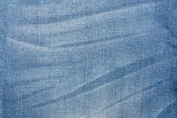 Worn blue jeans texture. Denim fabric background.